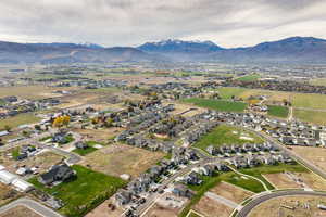Aerial view of property and surrounding area with a mountain backdrop and nearby suburban area