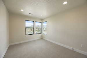 Unfurnished room with light colored carpet, recessed lighting, a mountain view, and a textured ceiling