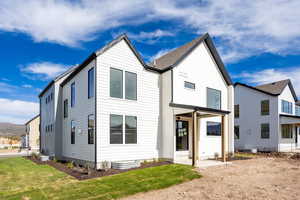 Rear view of property featuring a patio area and a lawn