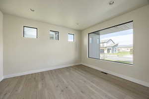 Empty room with plenty of natural light, light wood-style floors, and recessed lighting