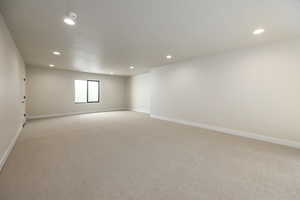 Spare room featuring light colored carpet, recessed lighting, and a textured ceiling