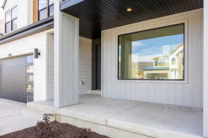 View of exterior entry with an attached garage and covered porch