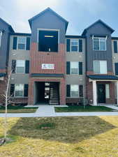 Townhome / multi-family property with brick siding, central AC unit, and a front lawn