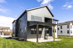 Back of property featuring a patio and a lawn