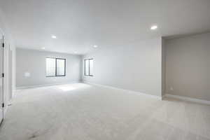 Unfurnished room featuring light colored carpet, recessed lighting, and a textured ceiling