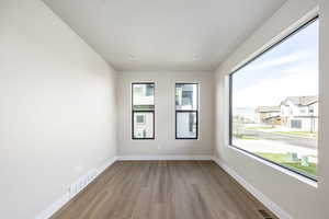 Spare room featuring wood finished floors, recessed lighting, and a residential view