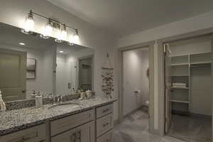 Full bathroom featuring toilet, a stall shower, vanity, and baseboards