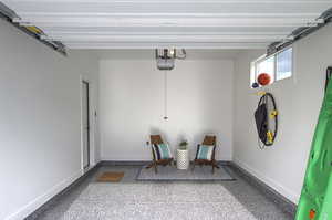 Garage featuring baseboards and a garage door opener