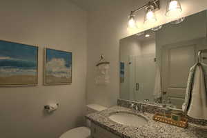 Full bathroom with a shower stall, vanity, and toilet