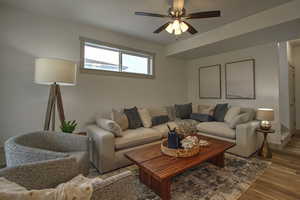 Living area with wood finished floors, baseboards, and a ceiling fan