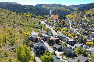 Birds eye view of property featuring a view of trees, a mountain view, and a residential view