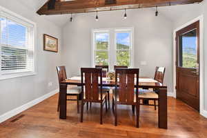 Dining area with plenty of natural light, visible vents, and lofted ceiling with beams