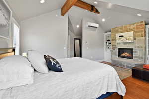 Bedroom featuring recessed lighting, wood finished floors, lofted ceiling with beams, and a wall mounted air conditioner