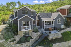 View of front facade featuring a porch and roof with shingles