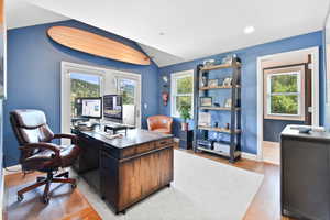 Office space featuring wood finished floors, baseboards, lofted ceiling, and recessed lighting