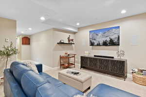 Carpeted living room with recessed lighting and baseboards