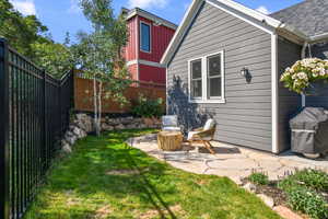 Back of property with a patio area, a shingled roof, a fenced backyard, and a yard