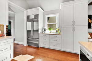 Kitchen featuring light countertops, white cabinets, and stainless steel built in fridge
