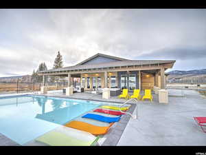 View of pool featuring an exterior structure, an outdoor structure, fence, a patio, and a fenced in pool