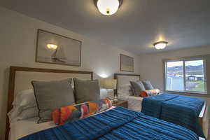 Bedroom with a textured ceiling and wood finished floors