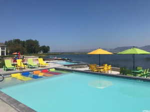Community pool with a water view and a patio