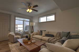 Living area featuring visible vents, ceiling fan, and wood finished floors