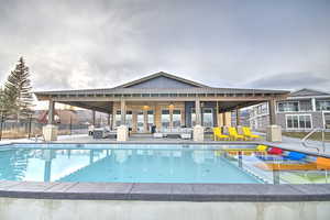 Pool featuring a water play area, a patio area, fence, and an outdoor hangout area