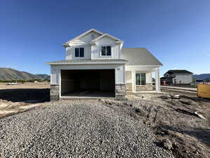 View of front facade with stone siding, a mountain view, a porch, and a garage