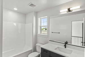 Full bath with toilet, visible vents, vanity, and  shower combination