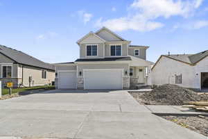 Craftsman house featuring concrete driveway, an attached garage, and stone siding