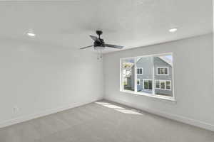 Spare room featuring baseboards, recessed lighting, ceiling fan, and carpet floors