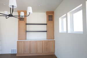 Interior space featuring baseboards, wood finished floors, and visible vents
