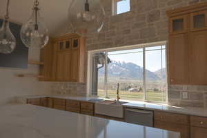 Kitchen with a sink, a mountain view, tasteful backsplash, open shelves, and light countertops