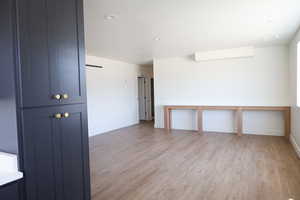 Empty room featuring light wood-type flooring, baseboards, and recessed lighting