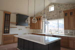 Kitchen with a sink, tasteful backsplash, open shelves, and lofted ceiling