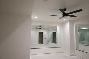 Interior space with finished concrete flooring, ceiling fan, baseboards, and recessed lighting