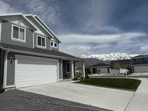 View of front facade featuring board and batten siding, a mountain view, a garage, and concrete driveway
