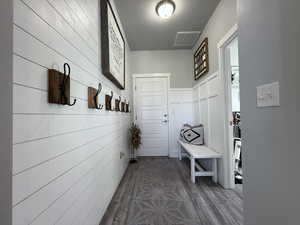 Mudroom featuring dark wood-type flooring, visible vents, and a textured ceiling