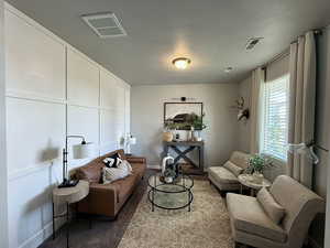 Living area with visible vents, baseboards, and a textured ceiling