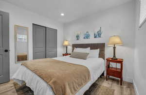 Bedroom featuring a closet, baseboards, light wood finished floors, and recessed lighting