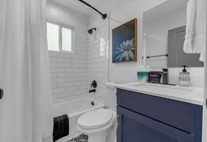 Bathroom featuring shower / tub combo, toilet, and vanity