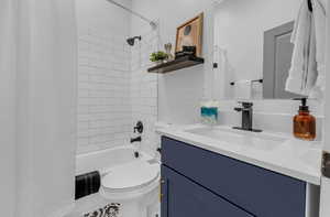 Bathroom featuring shower / bath combo with shower curtain, vanity, and toilet