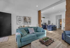 Living room with light wood-style flooring and recessed lighting