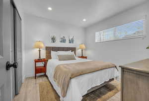 Bedroom with a closet, baseboards, light wood finished floors, and recessed lighting