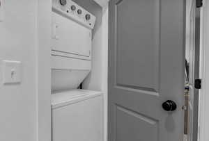 Laundry room with stacked washer and dryer and laundry area