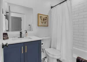Full bathroom featuring shower / tub combo, toilet, and vanity