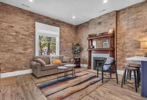Living area featuring visible vents, baseboards, and wood finished floors