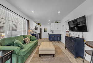 Living room featuring light wood finished floors, baseboards, and recessed lighting