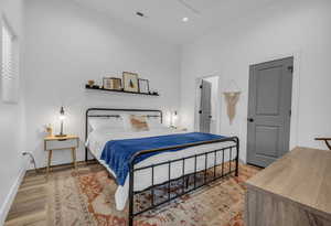 Bedroom with visible vents, baseboards, recessed lighting, and wood finished floors