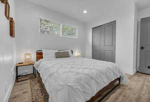 Bedroom featuring baseboards, light wood-type flooring, and recessed lighting